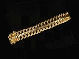 a close up of a gold bracelet on a black background