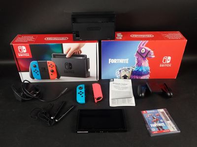 une Nintendo Switch Lite avec une manette et des accessoires posée sur la table