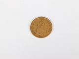 a gold coin sitting on top of a white surface