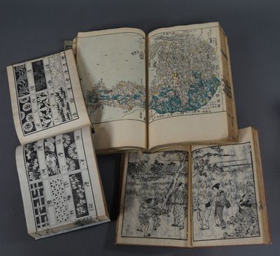 plusieurs livres ouverts, sur lesquels figurent des dessins, posés sur une table