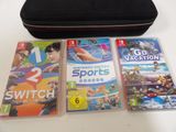 three nintendo wii games and a case on the table