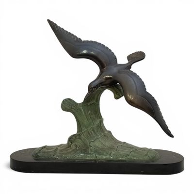 sculpture of two birds flying over a wave on a white background
