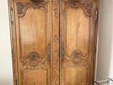 a wooden armoire in the corner of a room