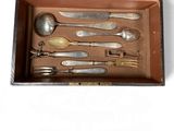 a wooden box with silverware in it on a white surface