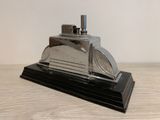 a silver and black model of a car on a wooden table