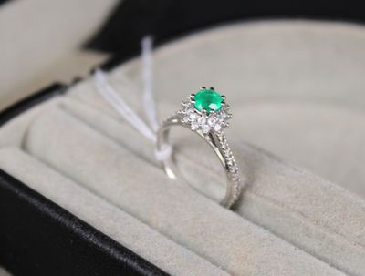 une bague qui se trouve dans une boîte, avec une pierre verte