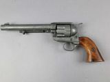 a close up of a revolver with a wooden handle on a white surface