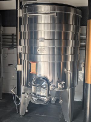 une grande cuve en acier inoxydable au milieu d'une pièce