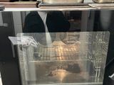 a person standing in front of an oven in a kitchen