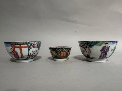 three small bowls are sitting on a white surface, one has a painting of a man and the other has a woman