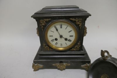 a small clock sitting next to a small clock on a table