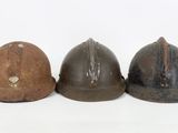 three helmets are lined up in a row on a white surface