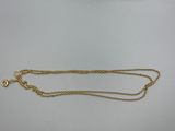 un collier en or auquel est attachée une chaîne