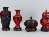 trois vases rouges posés les uns à côté des autres sur une table