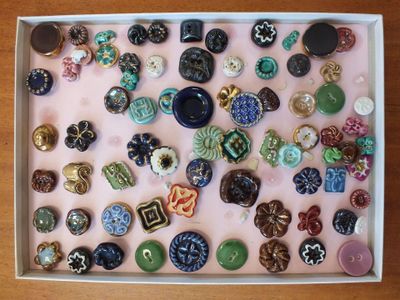 une photo d'une boîte de boutons posée sur une table