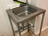 un lavabo dans un coin de la salle de bains, avec une brosse à dents posée sur le plan de travail