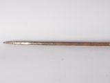 an old metal spoon with a wooden handle sitting on a white surface