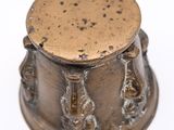 an old brass container with a lid on a white surface