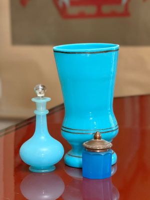 a blue glass vase and a blue glass bottle on a table