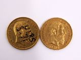 a close up of two gold coins on a white surface