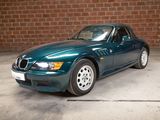 a green car parked in a garage with a brick wall