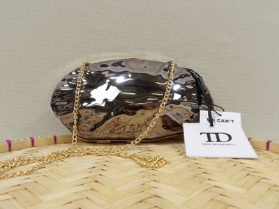 the purse is sitting on top of a wicker basket with a tag attached to it