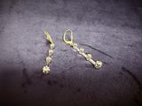 two pairs of gold plated earrings on a black surface
