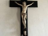a statue of jesus on a cross hanging on the wall