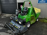 une photo d'une tondeuse à gazon verte garée devant un immeuble