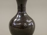a black vase that is sitting on a table