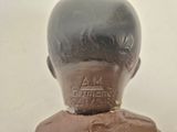 a small statue of a boy with a brown shirt on