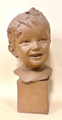 a clay sculpture of a boy on a pedestal