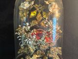une cloche en verre contenant un bouquet de fleurs