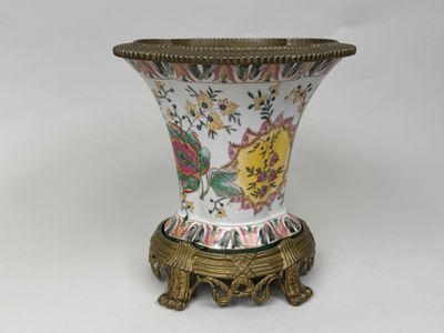 a vase that is sitting on a stand on a white surface