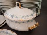 many plates and bowls stacked on a table with a lid