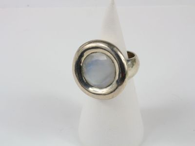un gros plan d'une bague sertie d'une pierre, posée sur un cône blanc