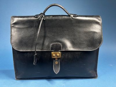 a black leather briefcase with a gold buckle on the front