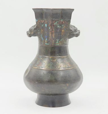 un vase en métal posé sur une surface blanche