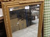 un miroir posé sur le sol à côté d'une chaise