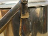 a silver pot with a handle on a table