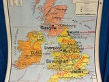 an old map of the british isles on display in front of a blue curtain