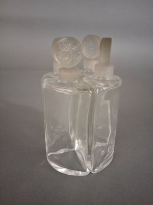 deux flacons de parfum transparents posés sur une table
