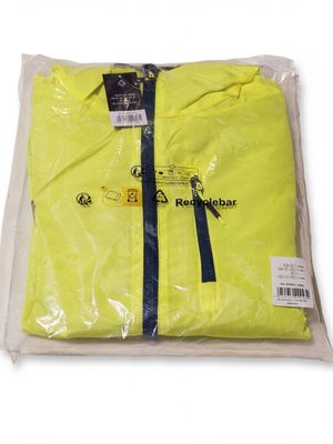 un t-shirt jaune emballé dans un sac en plastique transparent et orné d'un ruban bleu