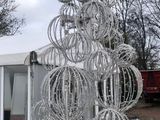 un grand sapin de Noël en fil de fer posé par terre