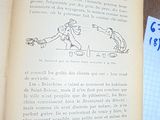 un livre ouvert, sur lequel figure un dessin, posé sur une table