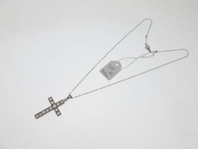 un gros plan d'un collier avec une croix suspendue à une chaîne