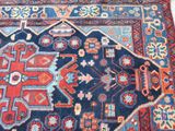 an image of a blue and red oriental rug on a wooden floor