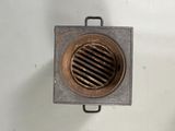 une petite bouche d'aération métallique au milieu d'un mur