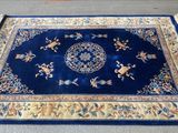 tapis oriental bleu posé sur la moquette dans une pièce dont le sol est recouvert de moquette