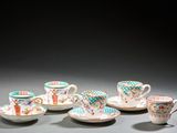 Plusieurs tasses et soucoupes sont alignées sur une table